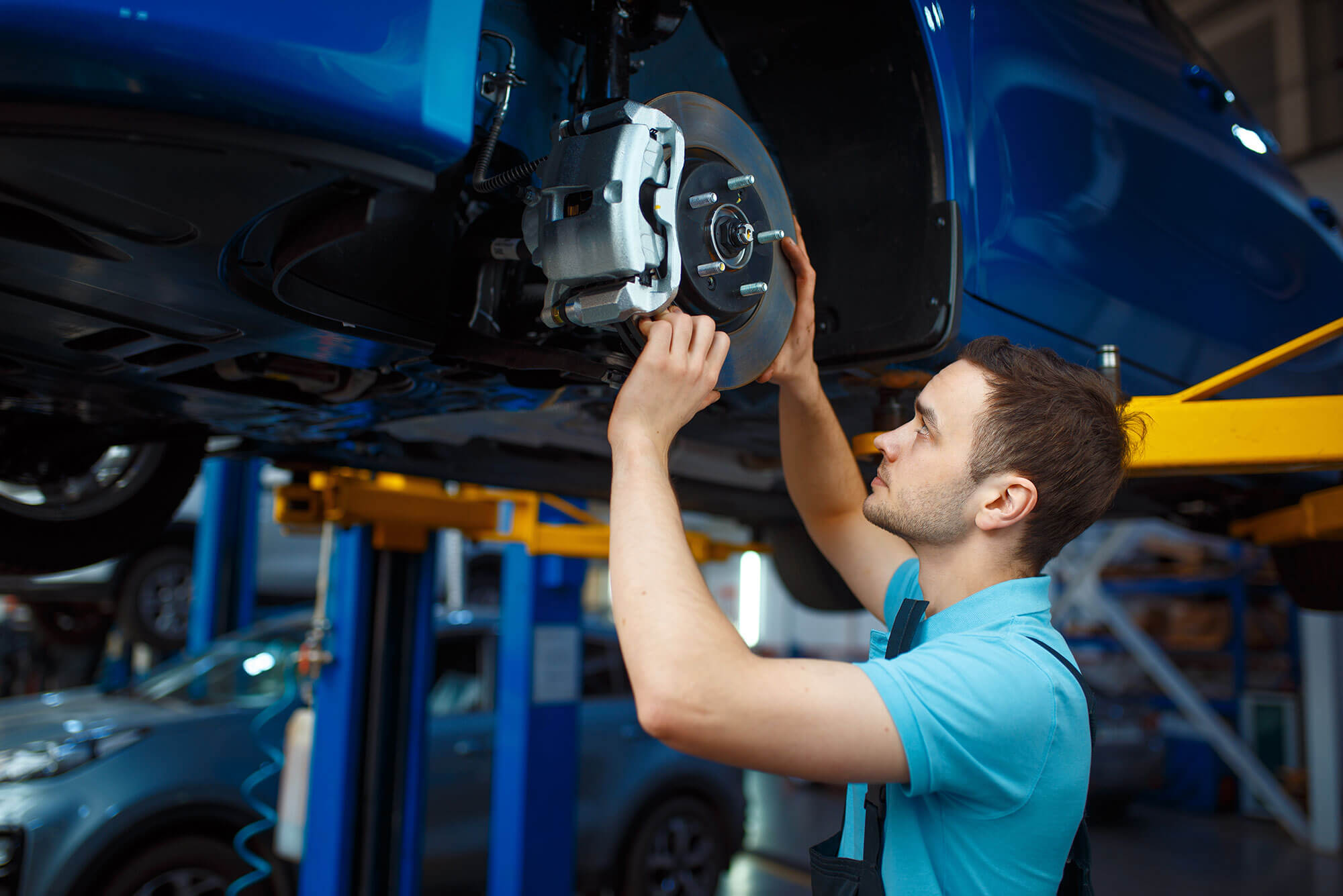 Repairman repairing vehicle on lift, car service