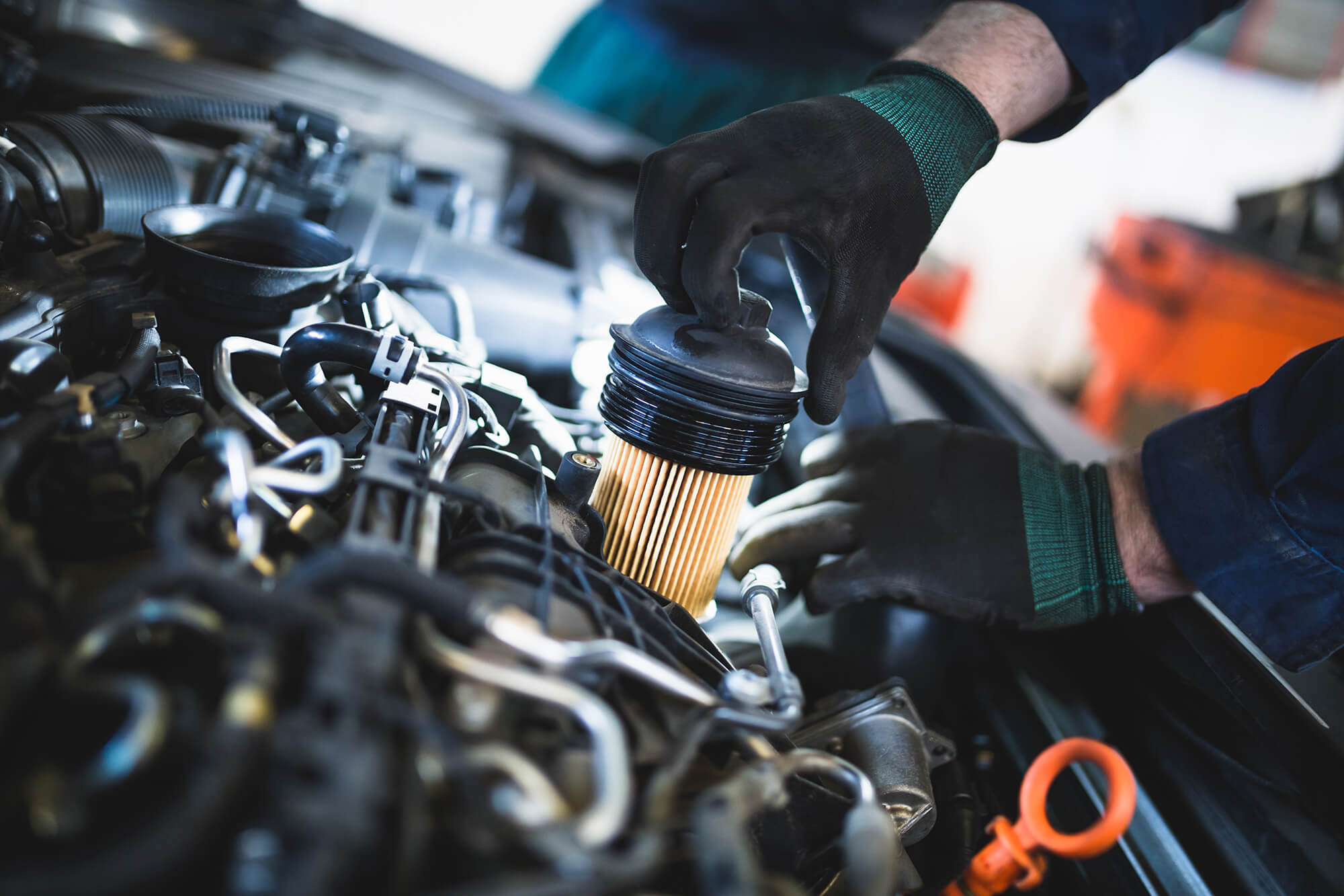 Close up hands of unrecognizable mechanic doing car service and maintenance. Oil and fuel filter changing.